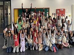 Gruppenfoto mit Kindern einer ersten Klasse, lachend, jubelnd